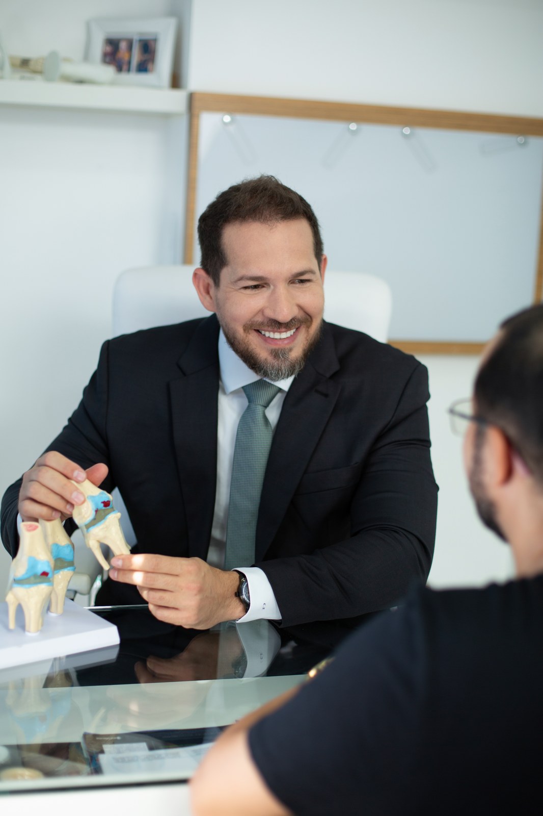 Consulta médica com modelo anatômico de joelho